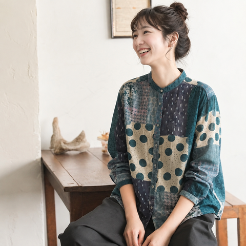 パッチワーク風の柄シャツの襟元と袖のシルエットが分かる座り姿の着用イメージ