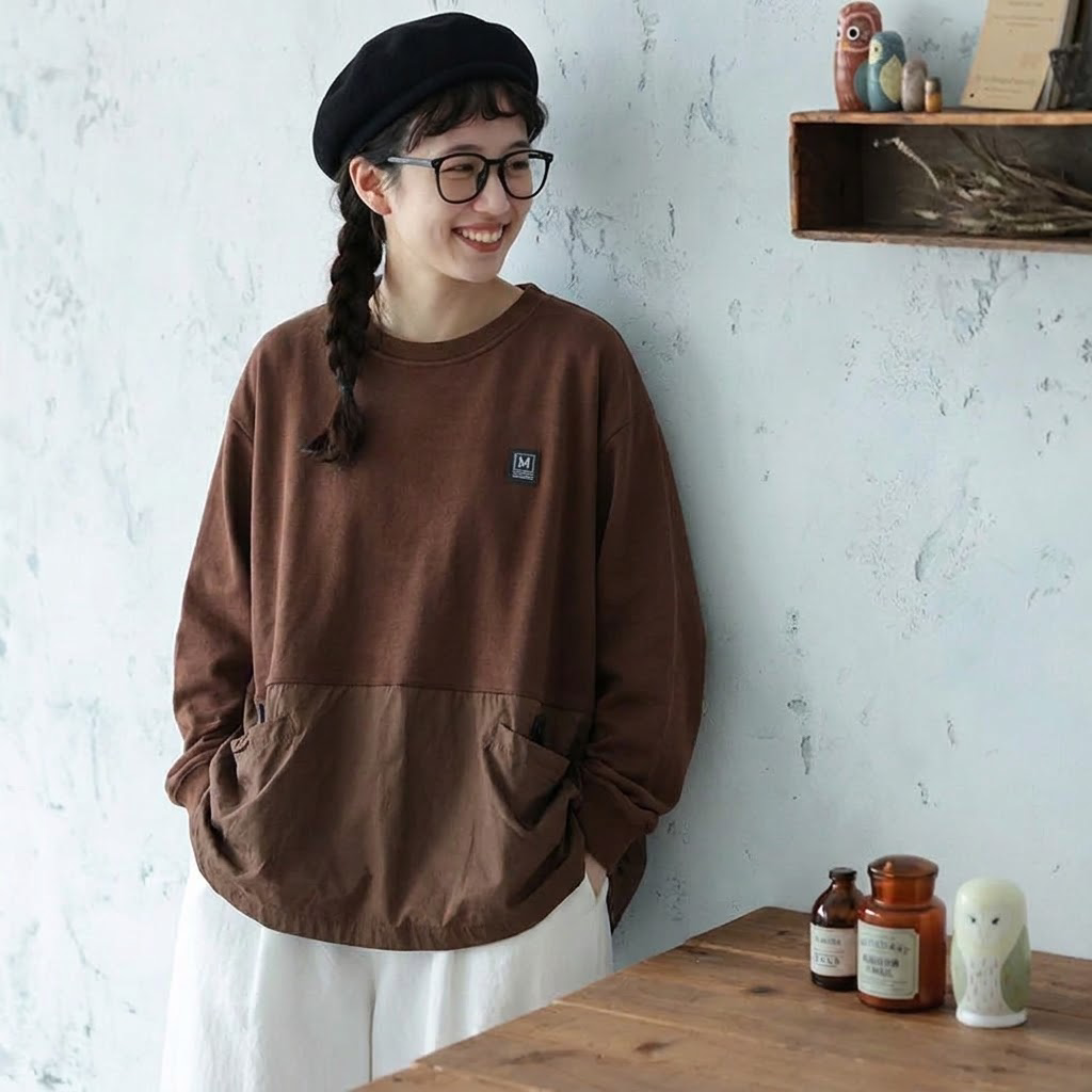 ブラウンのポケット付き長袖Tシャツと白いボトムスを合わせたコーディネート
